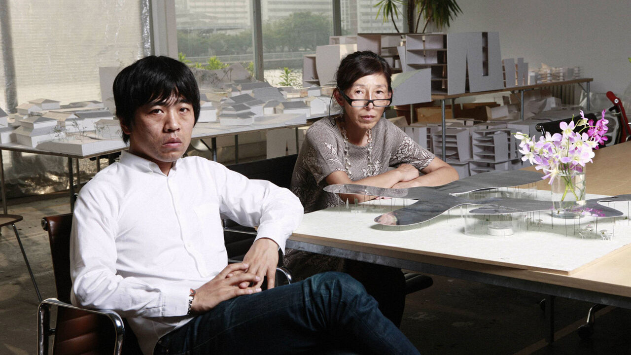 Kazuyo Sejima (rechts) und Ryue Nishizawa (links) von Sanaa sitzen vor dem Modell für den Serpentine Gallery Pavillion in ihrem Büro in Tokyo
