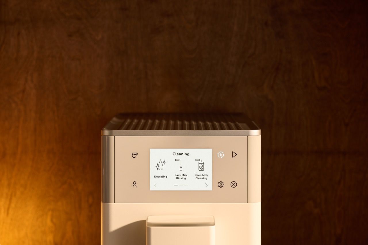 Nahaufnahme des Displays eines KitchenAid KF4 Kaffeevollautomaten; im Men&uuml; &bdquo;Cleaning&ldquo; sind Entkalken sowie Reinigungsoptionen f&uuml;r das Milchsystem zu sehen.