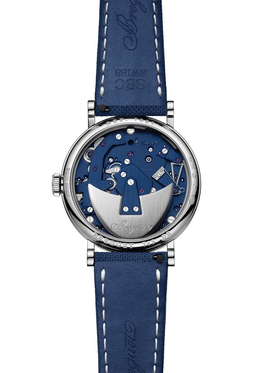 Die gläserne Rückseite der Breguet Tradition 7037BB zeigt das tiefblaue Uhrwerk und den silberfarbenen, halbmondförmigen Rotor aus Platin mit Gravur.