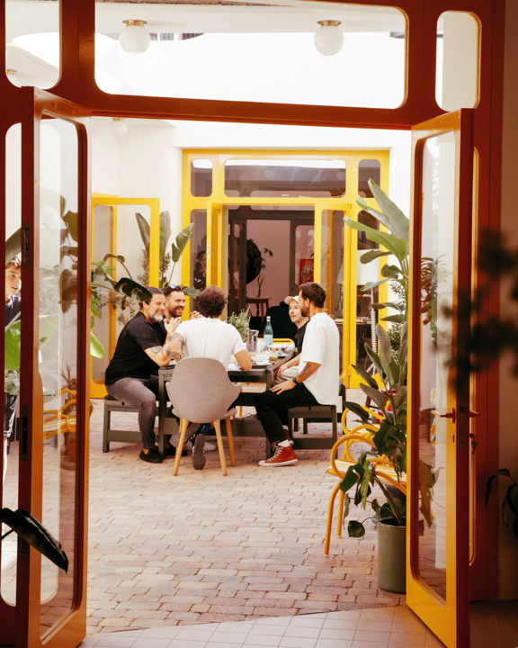 Leute am Tisch im Innnenhof von Jaime Hayons Studio