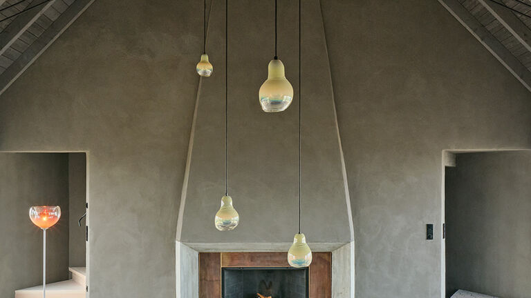 Kleine Kathedrale: Wie in einem Bühnenbild wird die Wohnhalle symmetrisch über die Seiten betreten; Schaufenster ermöglichen weite Blicke in die märchenhafte Moränenlandschaft. Der zentrale Kamin ist von einem Renaissance-Palast inspiriert. Die Wohnhalle